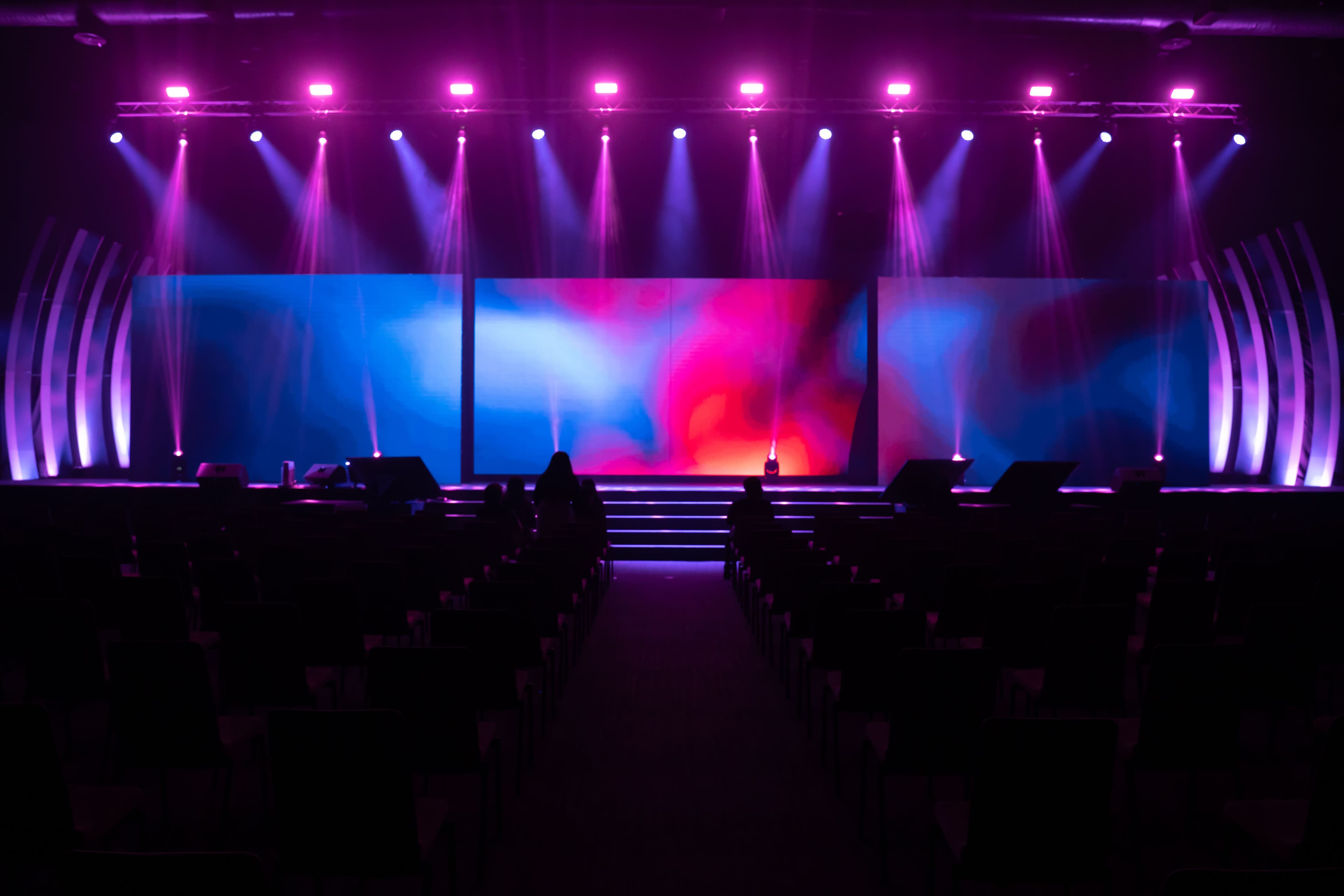 Professional event stage with dramatic lighting and audiovisual setup